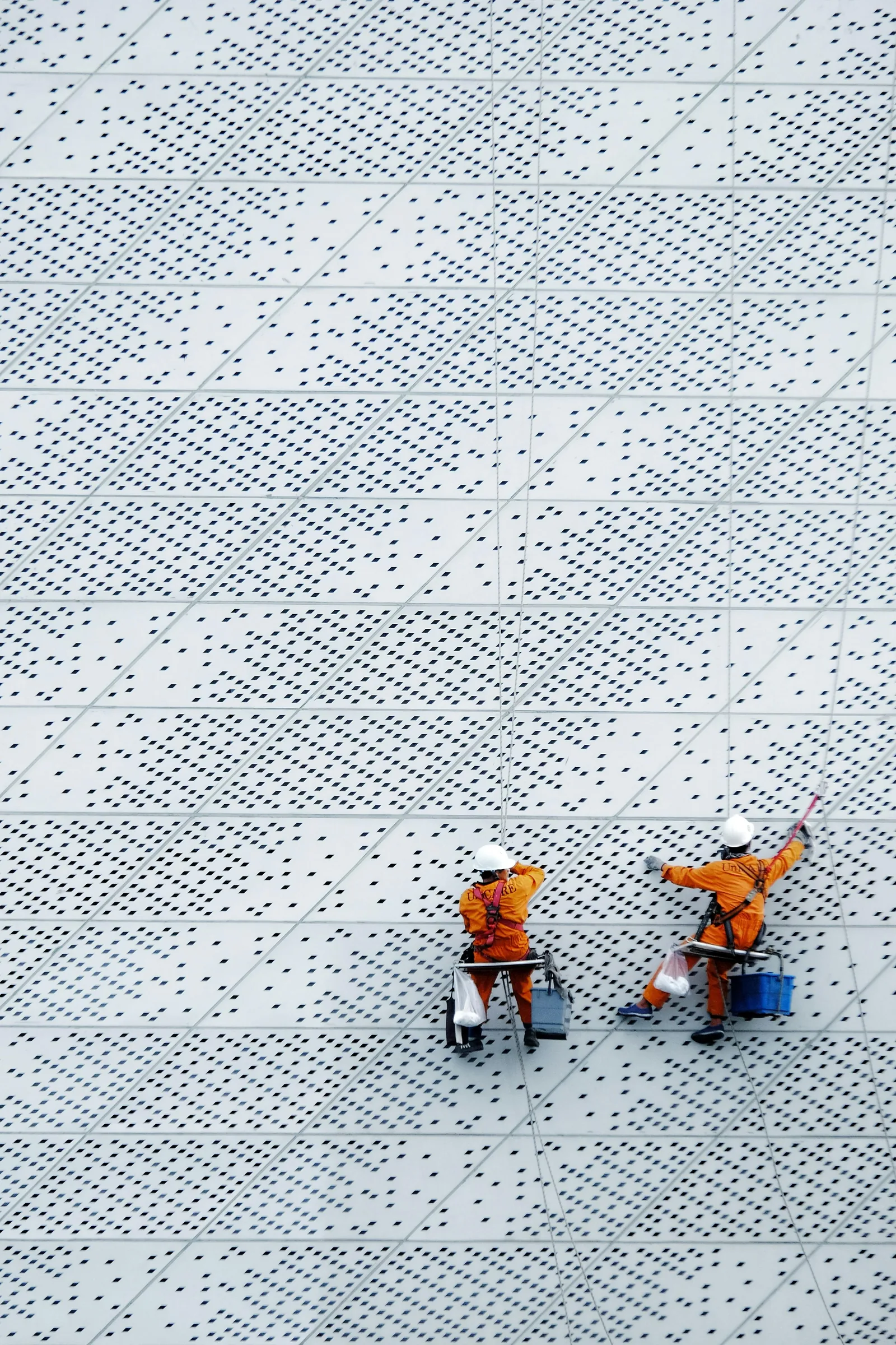 Technicians maintaining a building facade